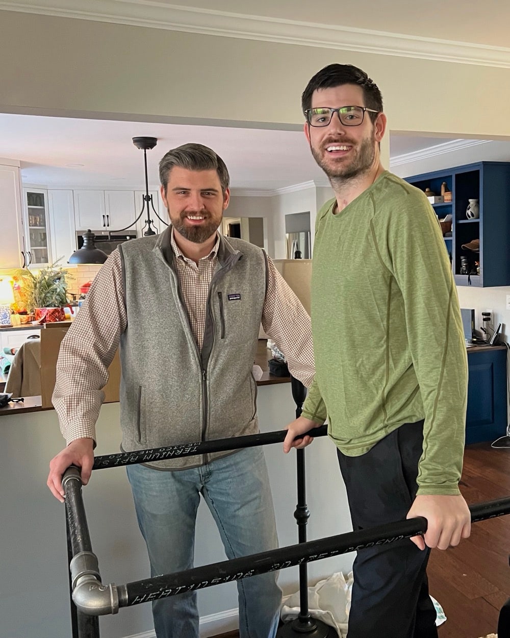 William Dugal practicing standing between parallel bars during rehabilitation, with support